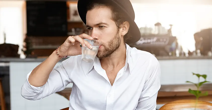 Beber 2,5 litros de agua cada día hombre bebiendo de un vaso