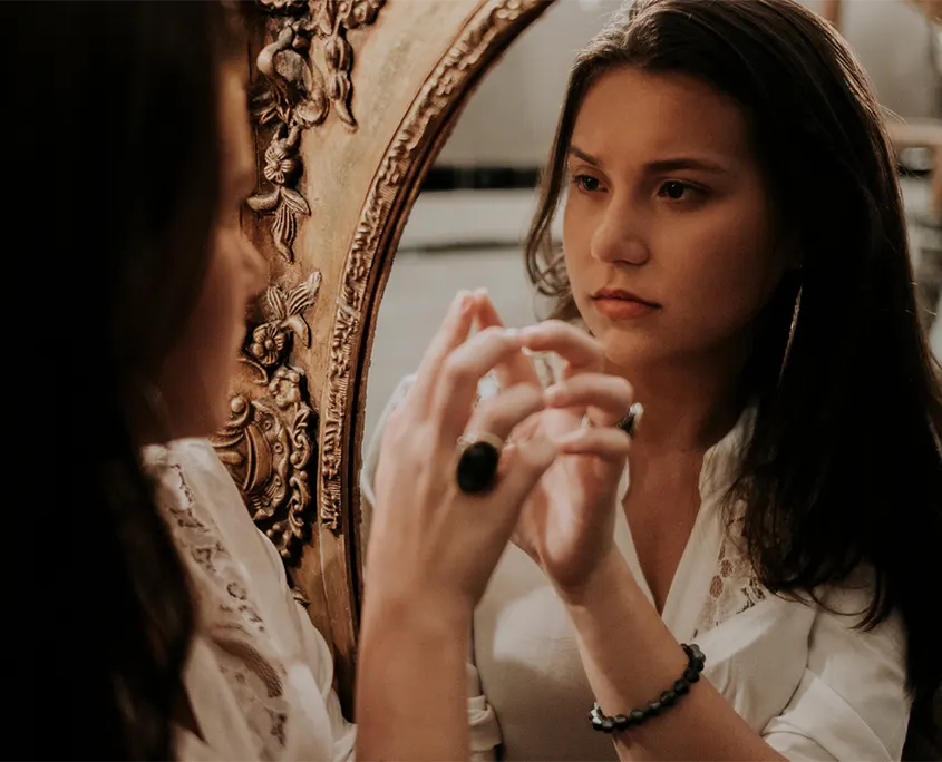 mujer mirándose frente al espejo quiropráctica Badalona
