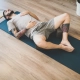 Joven tumbado boca arriba sobre una esterilla de yoga en actitud de descanso