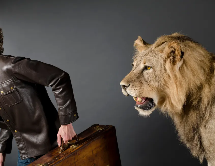 hombre con maleta huyendo de un león