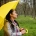 mujer con un paraguas amarillo resguardándose de la lluvia