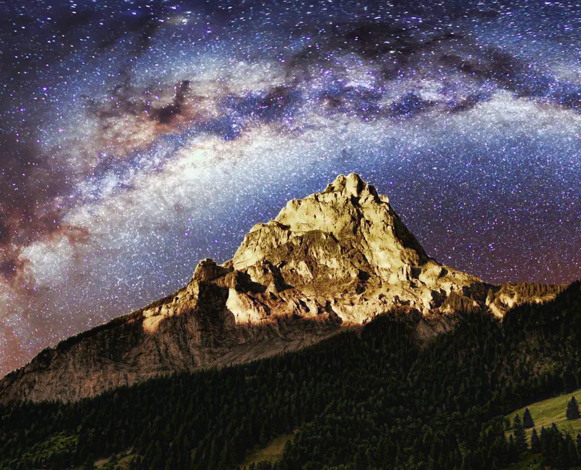 Imagen de una montaña con el cielo estrellado al fondo