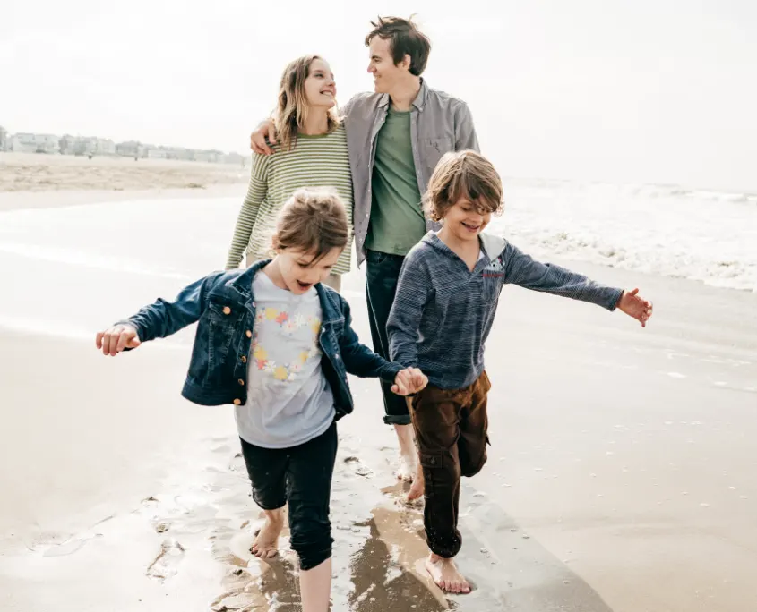 Foto de familia paseando por la playa enfrentando el estres