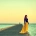Mujer caminando por un embarcadero de madera mirando al mar