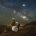 Foto de mujer sentada mirando a las estrellas en plena naturaleza