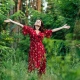 Foto de mujer en el bosque rodeada de árboles con los brazos en cruz reconectando con la naturaleza