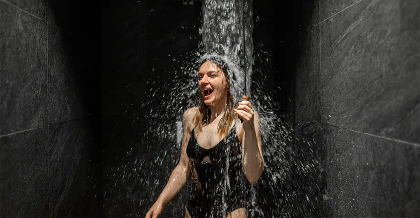 Mujer bajo la ducha de agua fría Quiropráctico Badalona