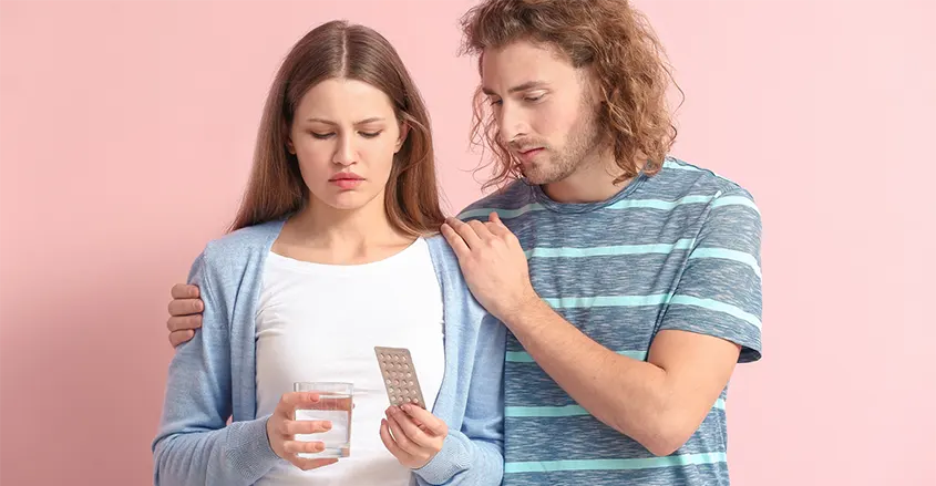 Imagen de una pareja con ella con un blister de anticonceptivos en la mano