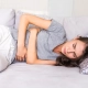 Imagen de mujer en cama con dolor menstrual