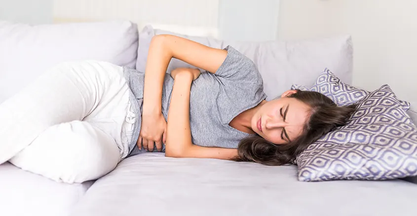 Imagen de mujer en cama con dolor menstrual