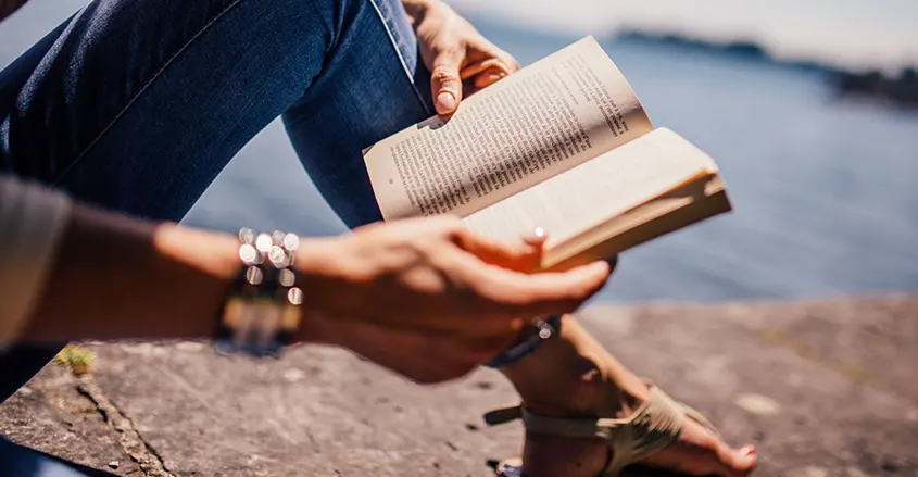 foto de mujer con libro la lado del mar leer diariamente consejo de salud Quiropráctica Badalona