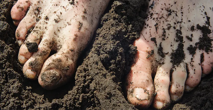 Foto de pies descalzos sobre el barro conectar a  tierra