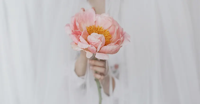 Foto de mujer con flor en la mano Quiropráctica Badalona