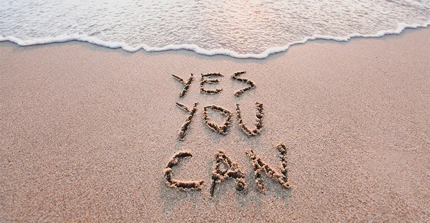 Imagen con el texto Yes you can escrito en la arena de la playa motivación Quiropráctico Badalona